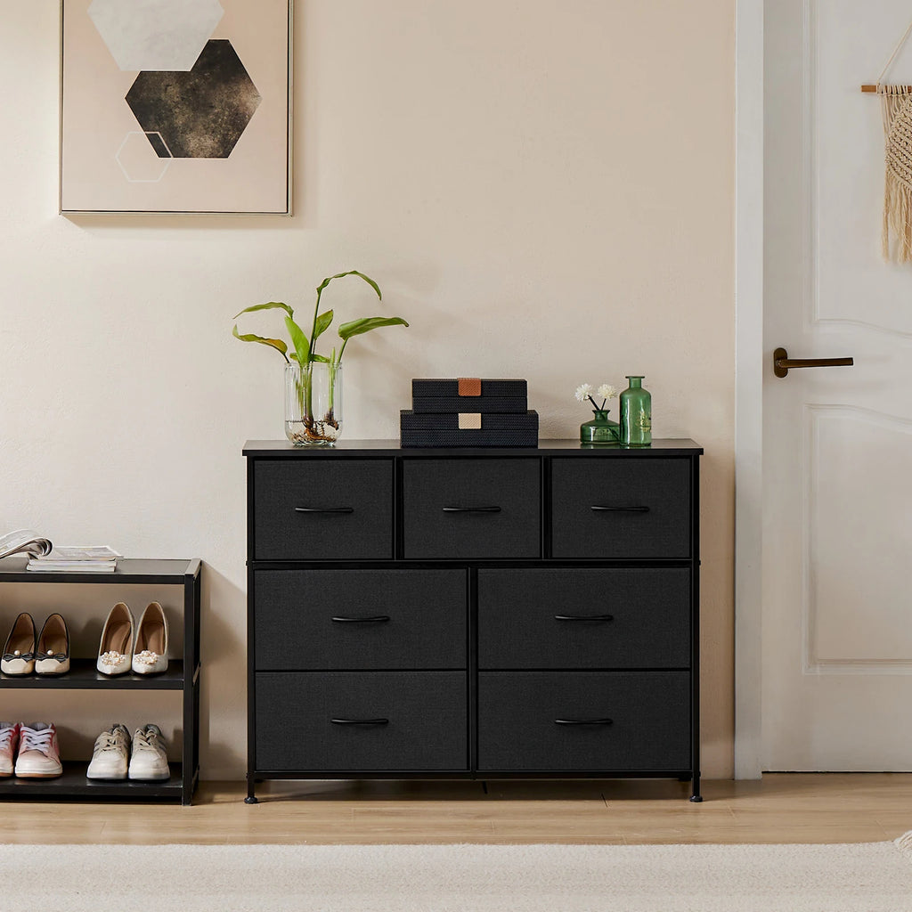 Black dresser with shoes and decor items in a room setting.