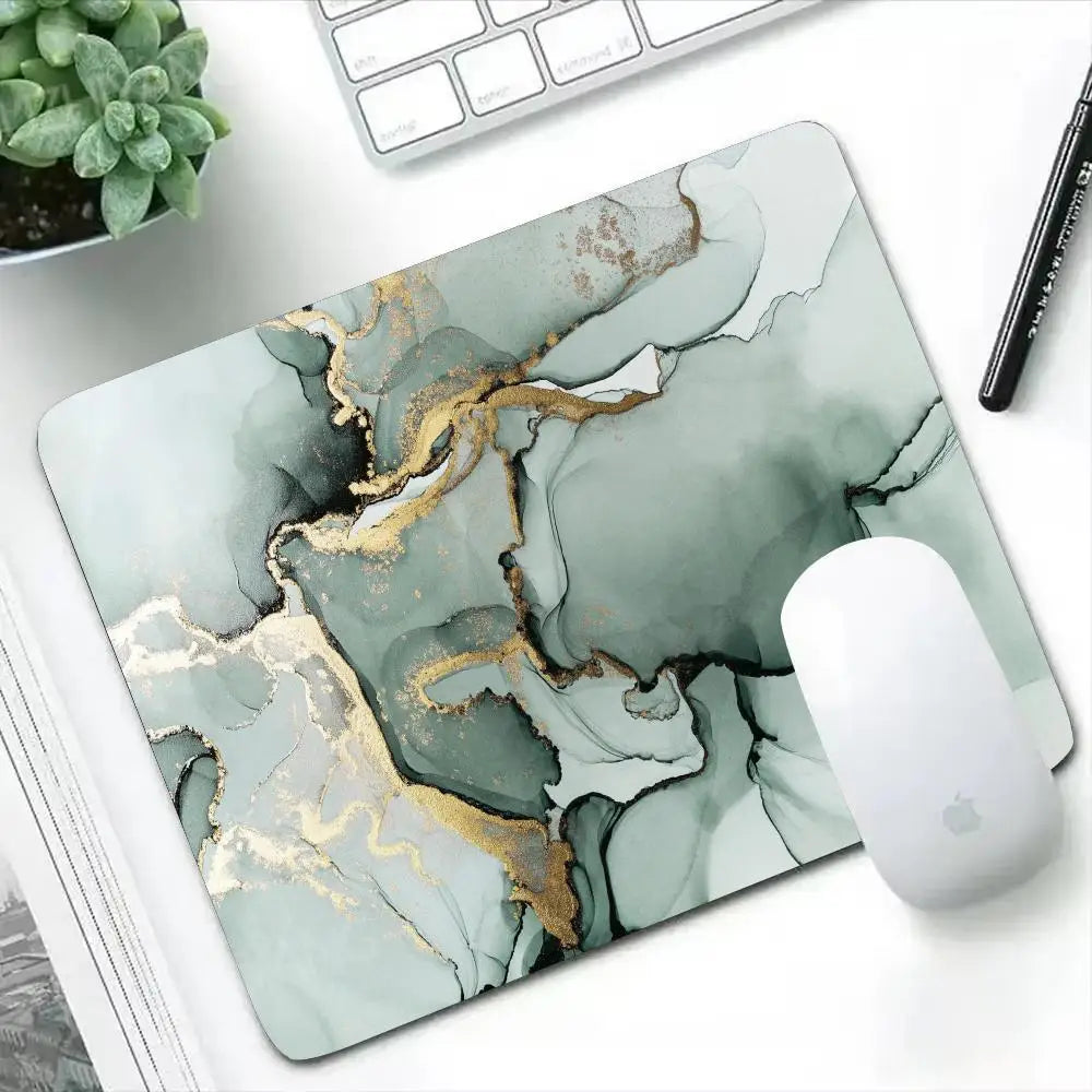 Marble-patterned mouse pad on a desk with a computer mouse, keyboard, and pen.