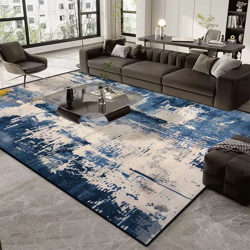 Living room with a blue and gray patterned rug, dark sofa, and modern decor.