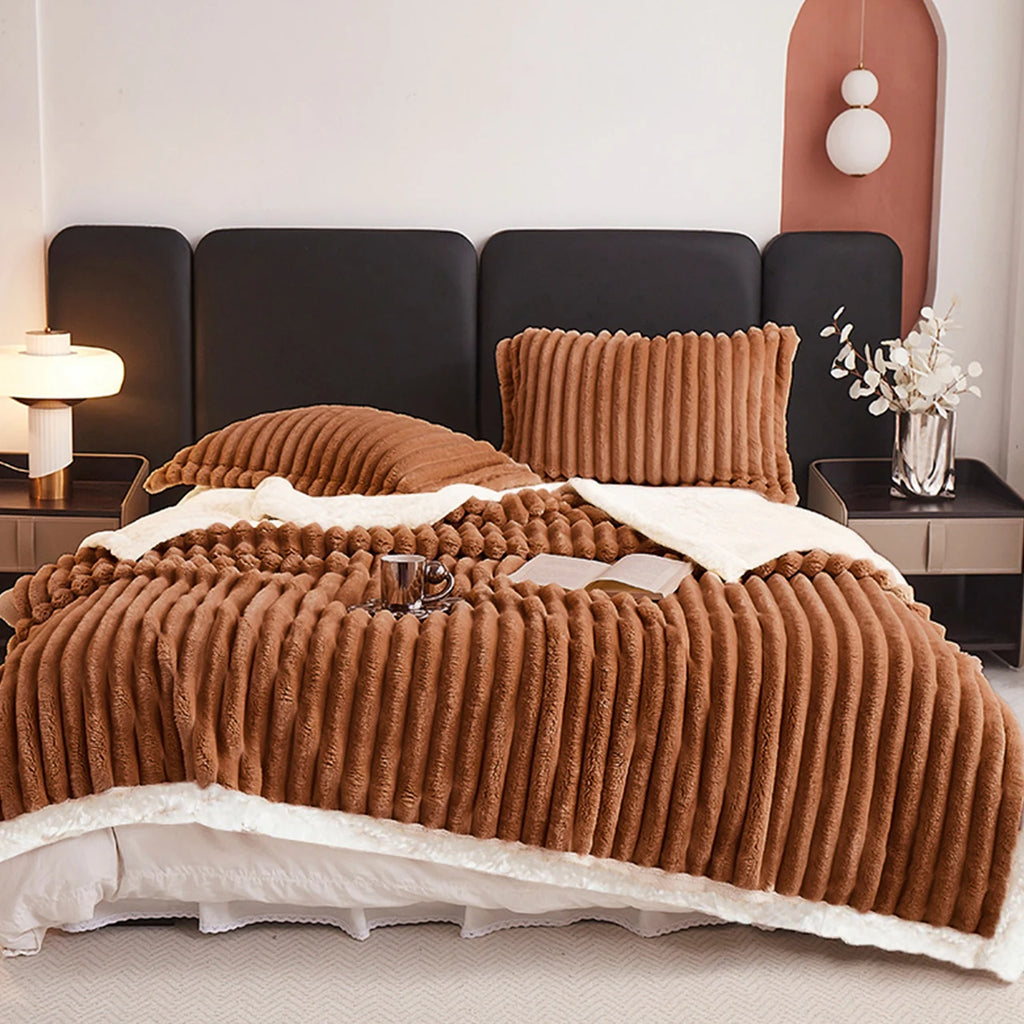 A cocoa brown textured blanket on a bed with matching pillows in a bedroom setting.