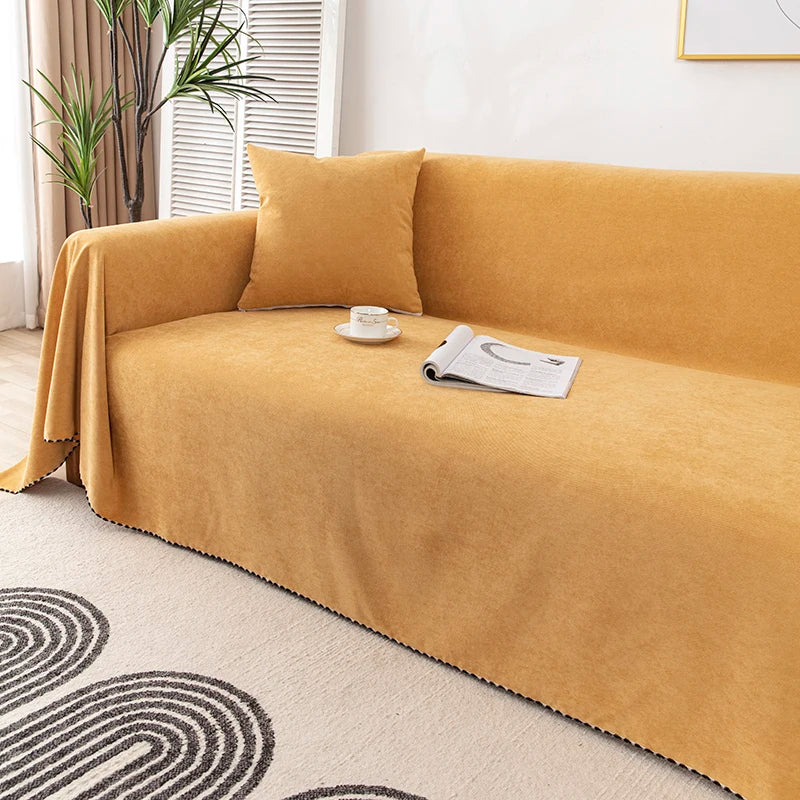 Yellow sofa with a blanket, cup, and newspaper in a living room setting.