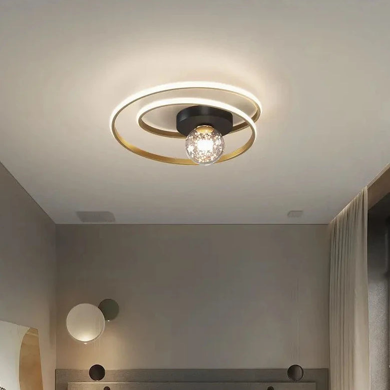 Close-up of black double-spiral LED ceiling light with textured amber glass globe against a white ceiling