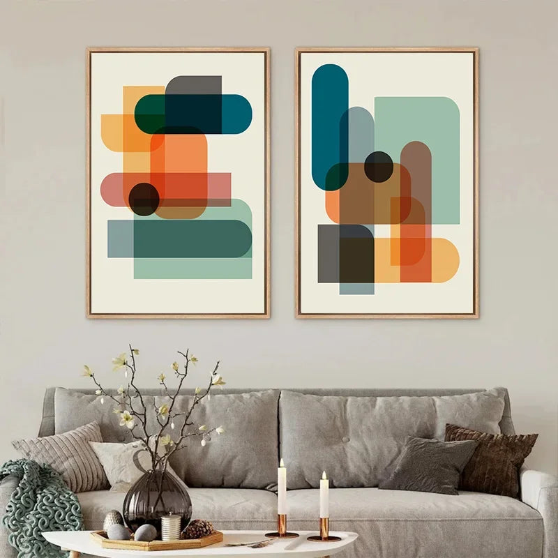 Two abstract art pieces on a wall above a grey sofa with decorative items.