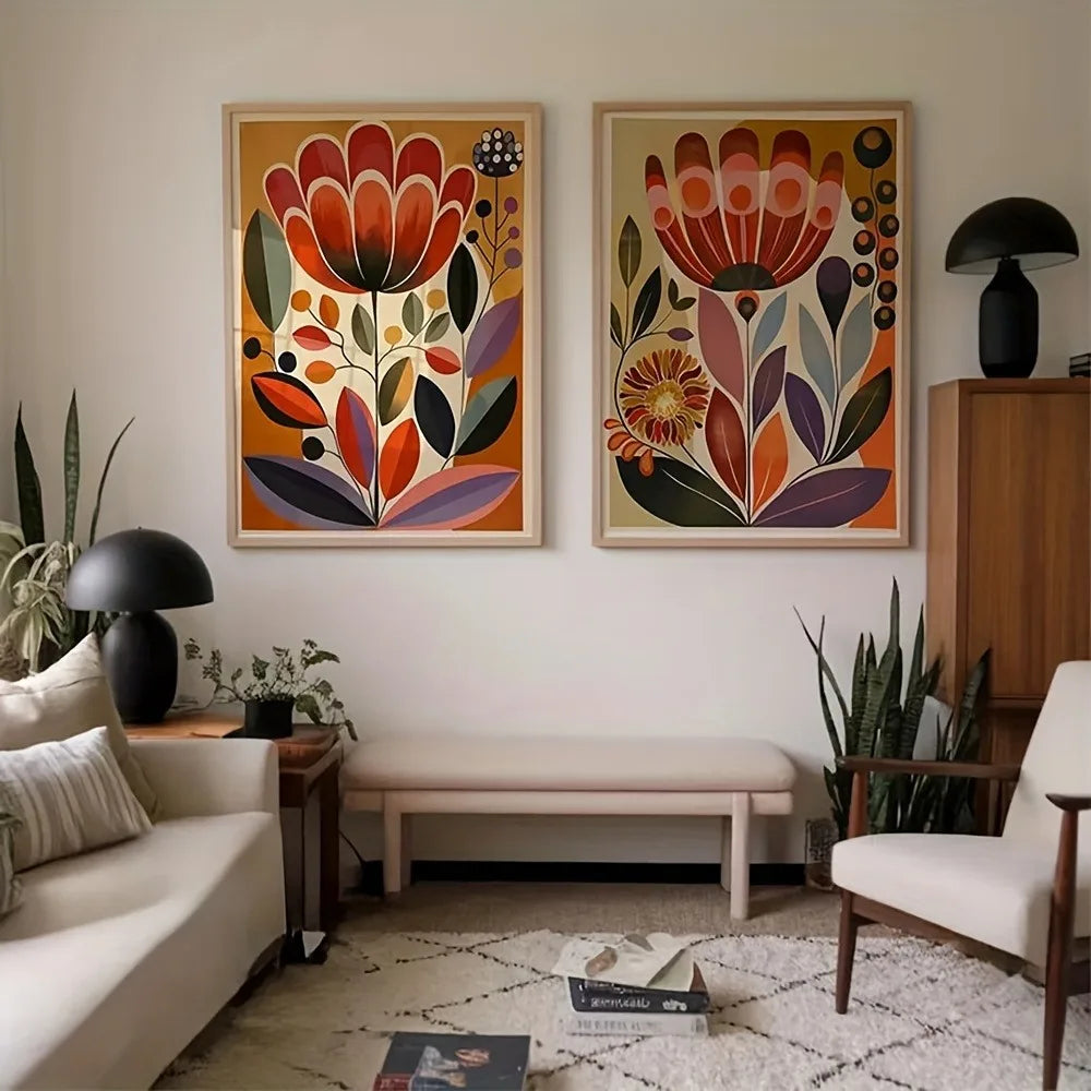 A pair of large unframed abstract floral canvas prints in gold frames leaning against a white wall.
