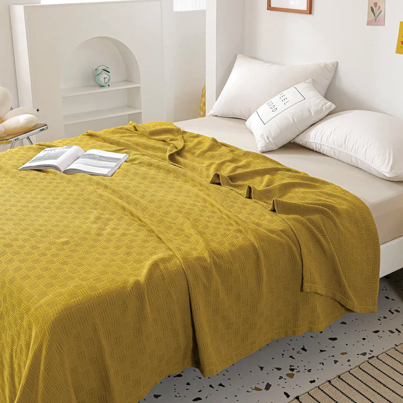 A olive cotton knit throw blanket with textured weave pattern.