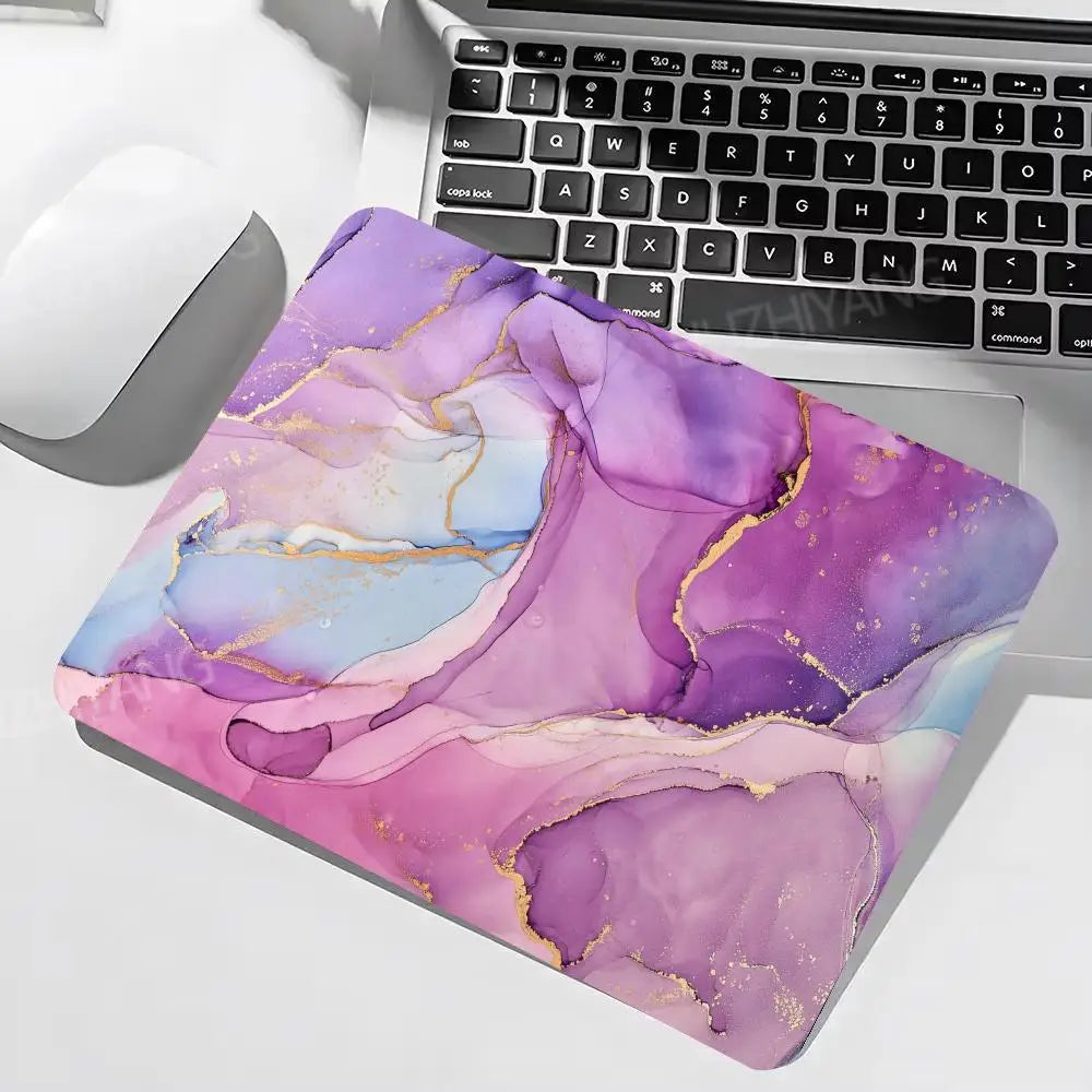 Colorful abstract mouse pad on a desk with a laptop and mouse.