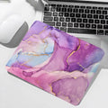 Colorful abstract mouse pad on a desk with a laptop and mouse.