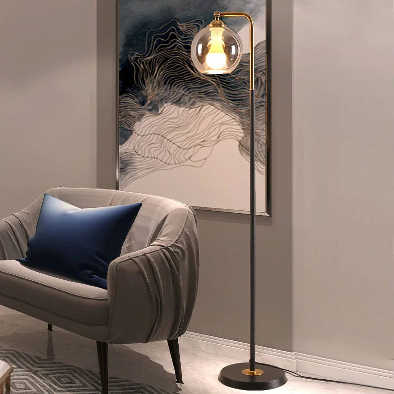 Black stem brass globe floor lamp in a neutral minimalist setting