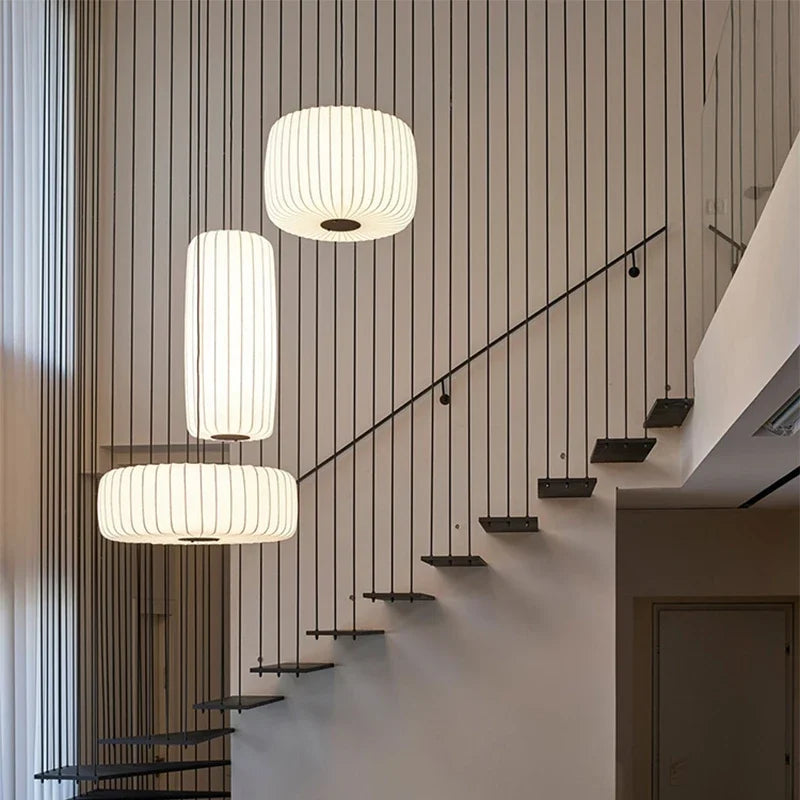 Modern staircase with pendant lights against a striped wall.
