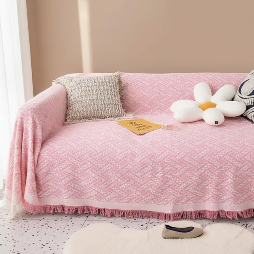 Blush pink coral fleece couch cover with fringe edging and soft decorative styling