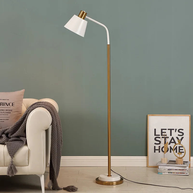 White arc floor lamp glowing warmly against a green wall