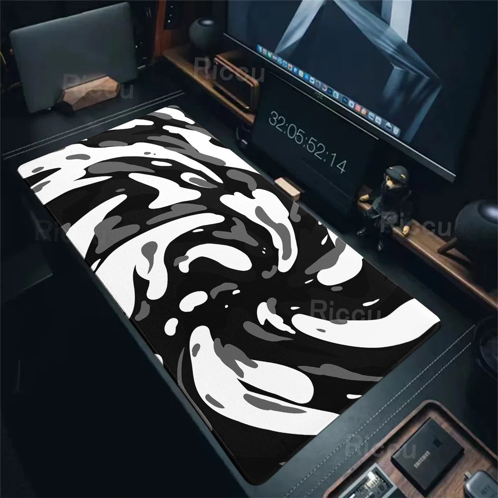 Black and white patterned desk mat on a desk with a computer monitor and keyboard.