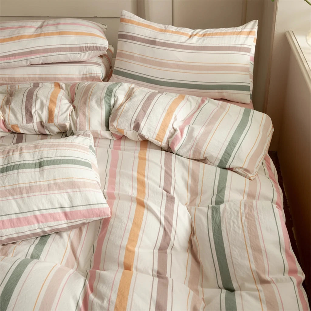 Striped bedding with pillows on a bed, featuring a card with text.