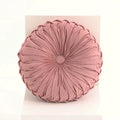 Pink round cushion with pleated texture on a light pink background