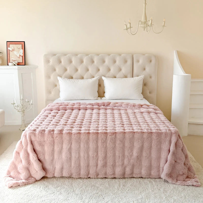 Pink blanket draped over a bed in a bedroom setting