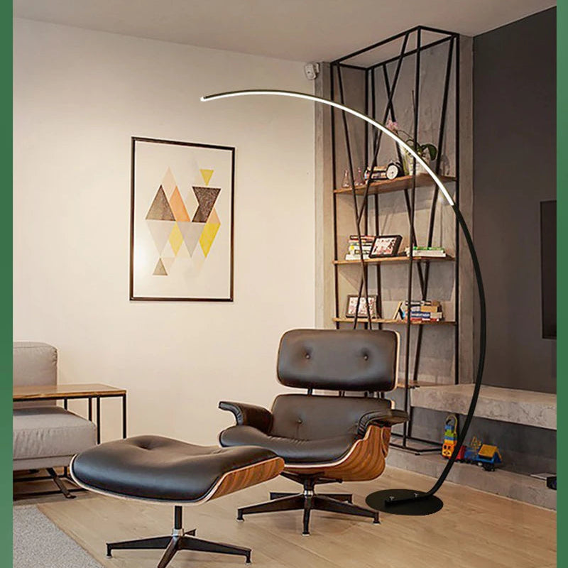 Modern living room with a black lounge chair, ottoman, and arc floor lamp.