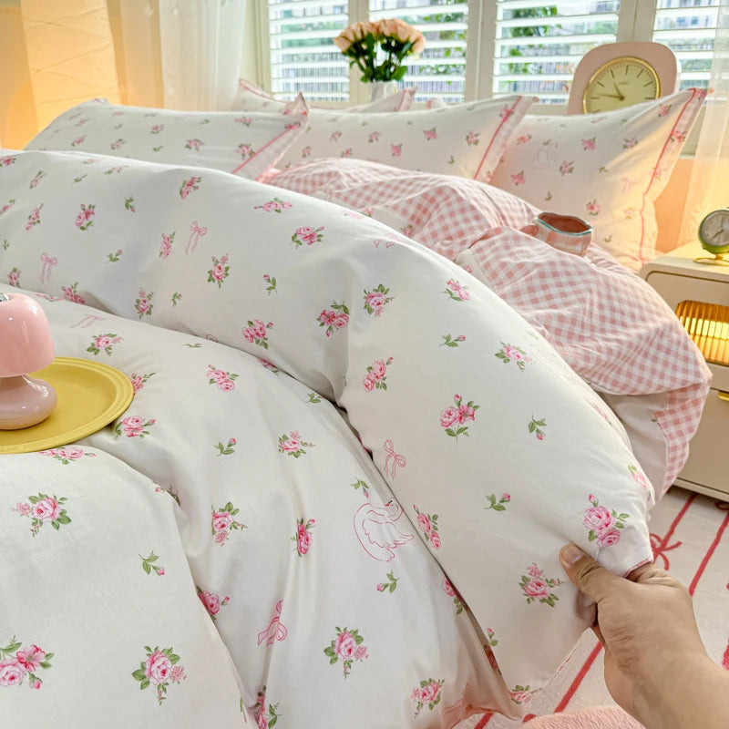 Dainty Sprig floral bedding featuring small pink rosebuds on white cotton with a pink gingham underside.