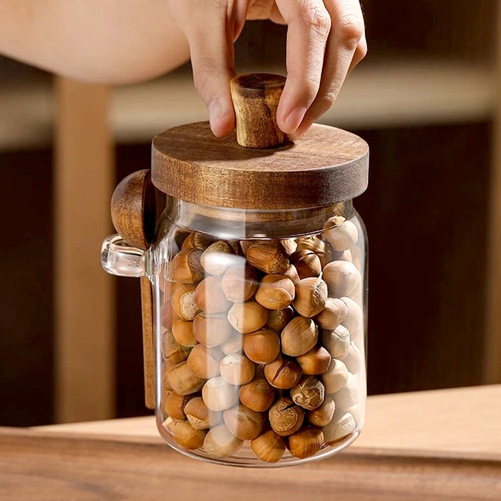 Glass jar with wooden lid filled with nuts on a wooden surface