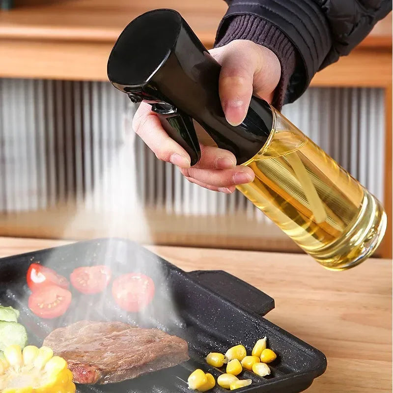 Person using an oil sprayer over a grill with vegetables and meat.