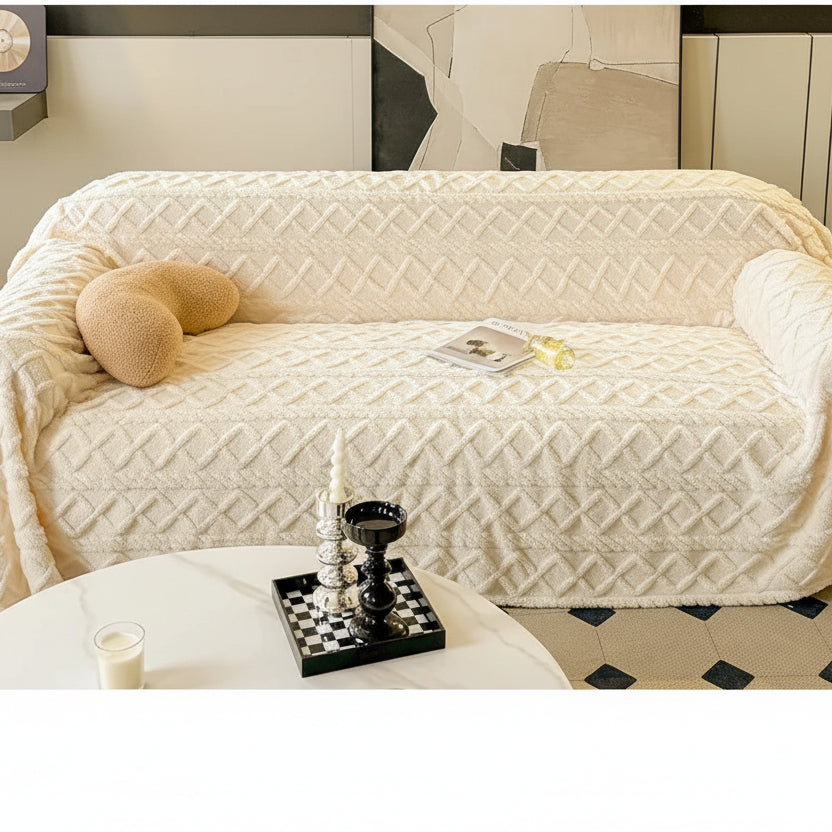 Beige sofa with textured cover and decorative pillows on a white surface.