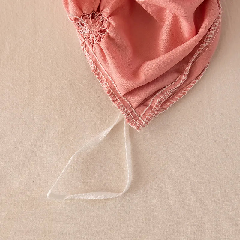 Pink fabric with lace trim on a beige background