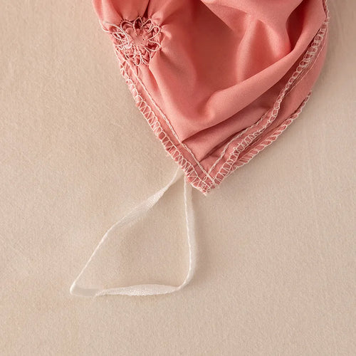 Pink fabric with lace trim on a beige background