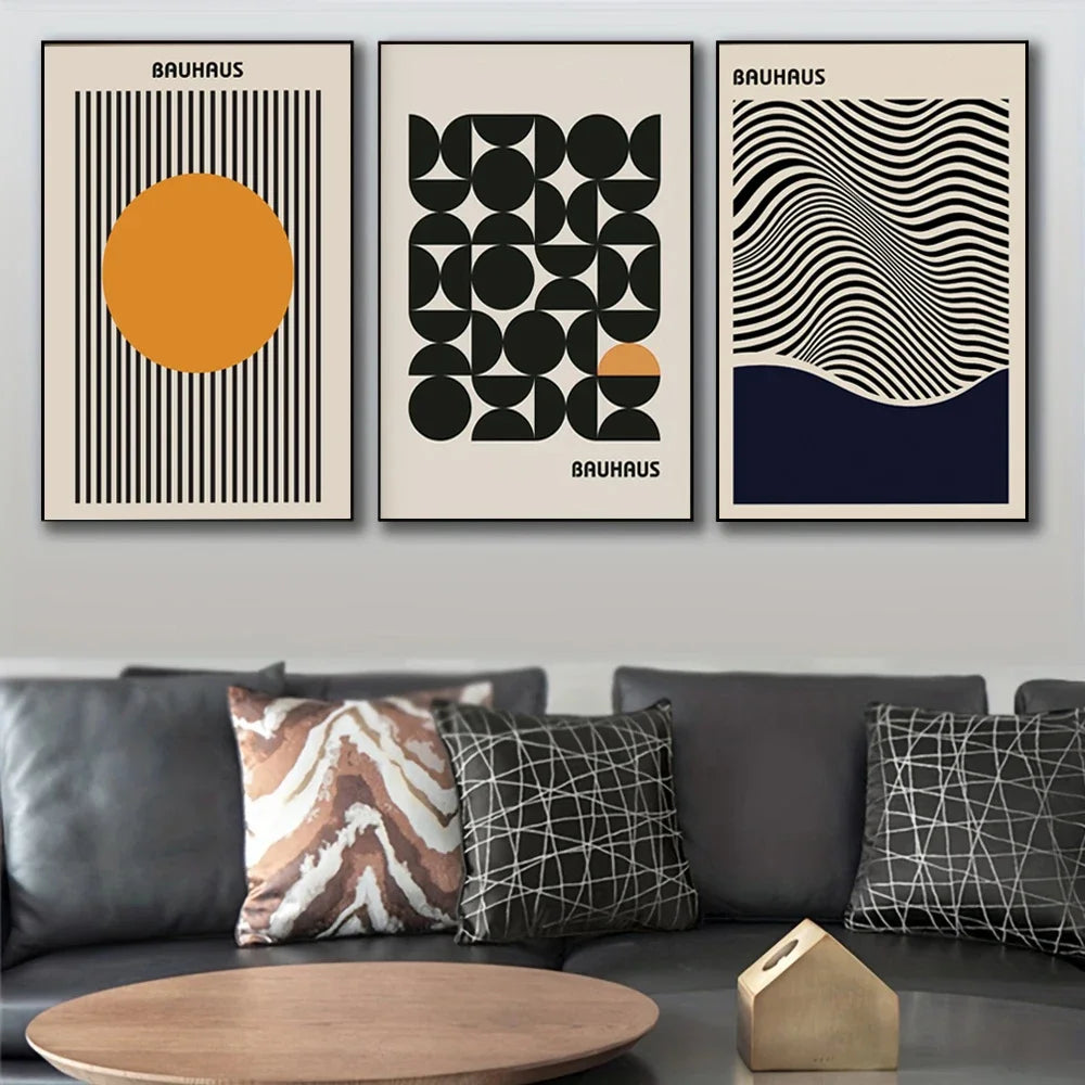 Three Bauhaus style posters on a wall above a sofa with patterned cushions.