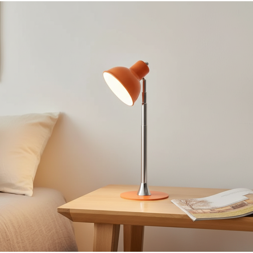 Orange desk lamp on a wooden surface with a magazine underneath