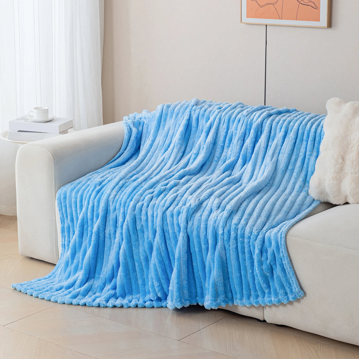 Blue blanket draped over a white sofa in a living room setting.