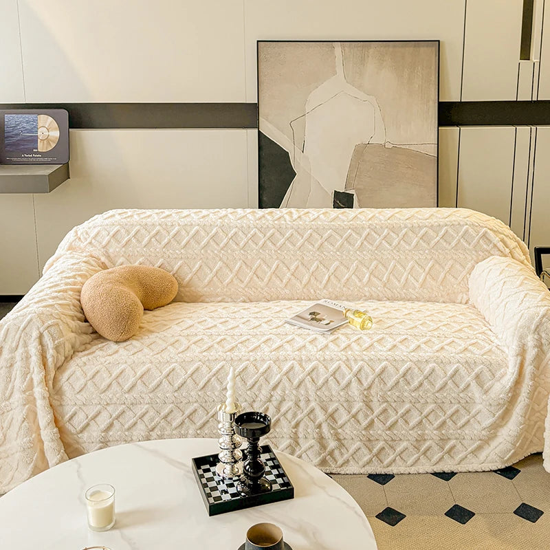 Beige textured sofa with decorative pillows and a small table in a modern living room.