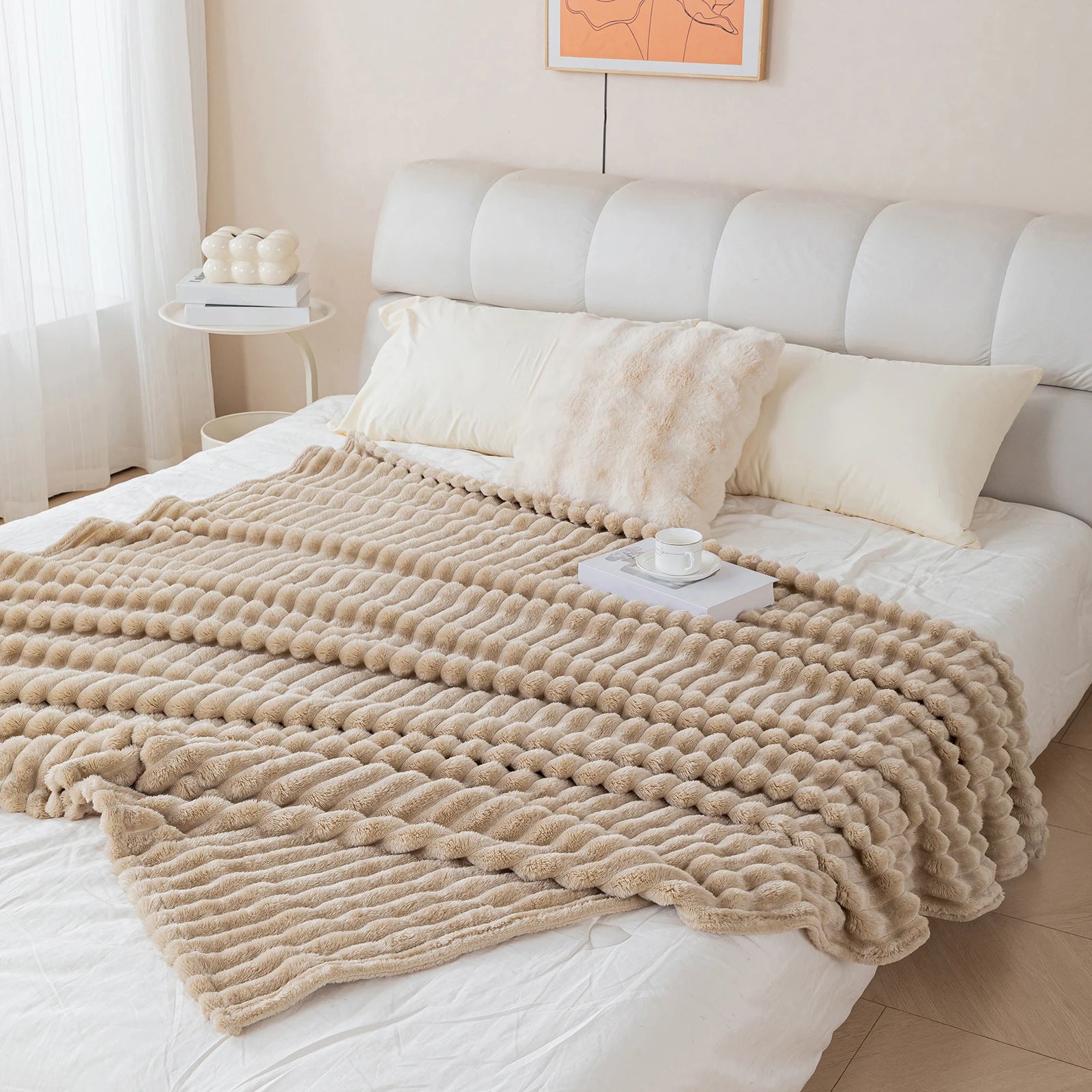 Beige blanket draped over a bed in a bedroom setting