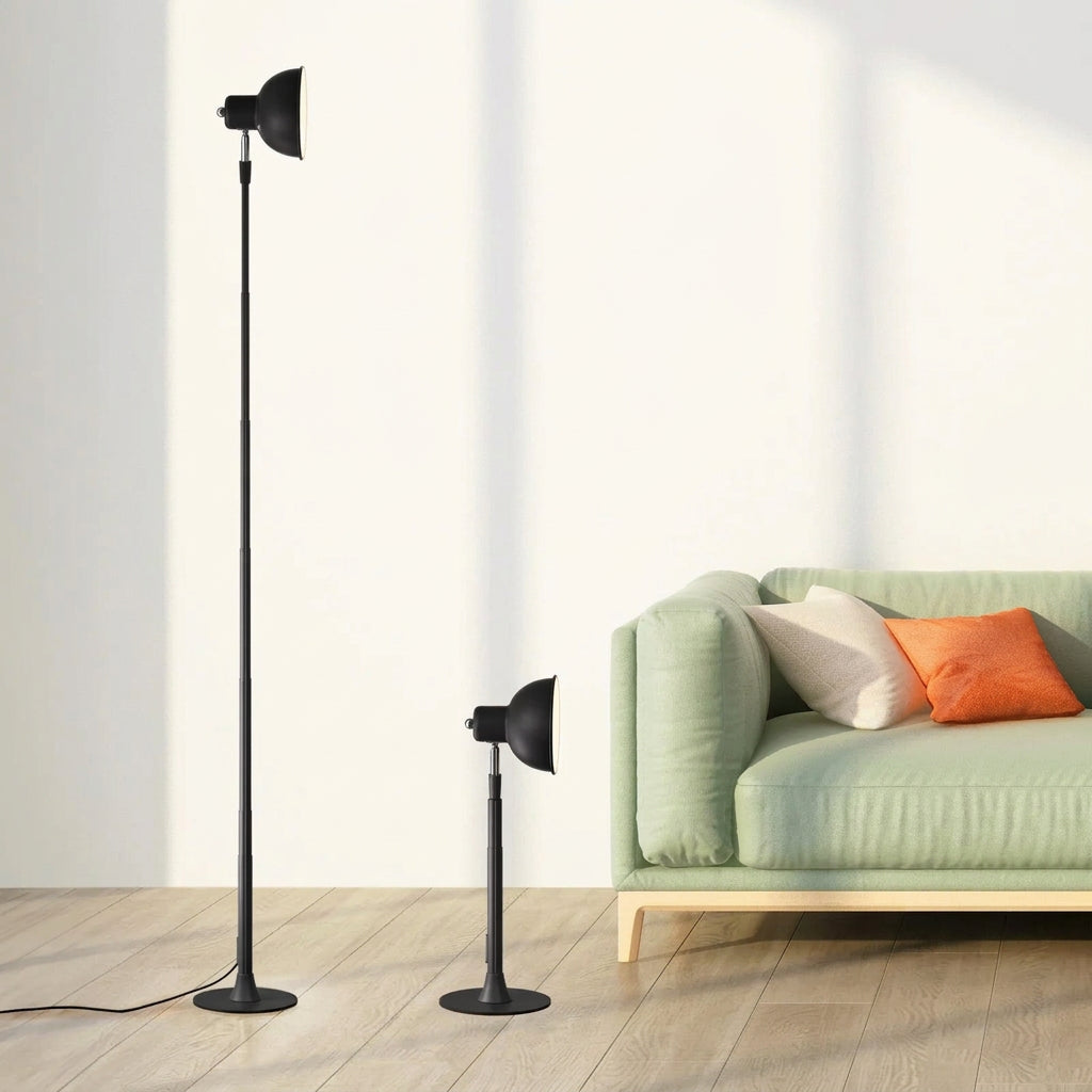 Black adjustable floor lamp shown at full 145 cm height and lowest 45 cm height, beside a green sofa