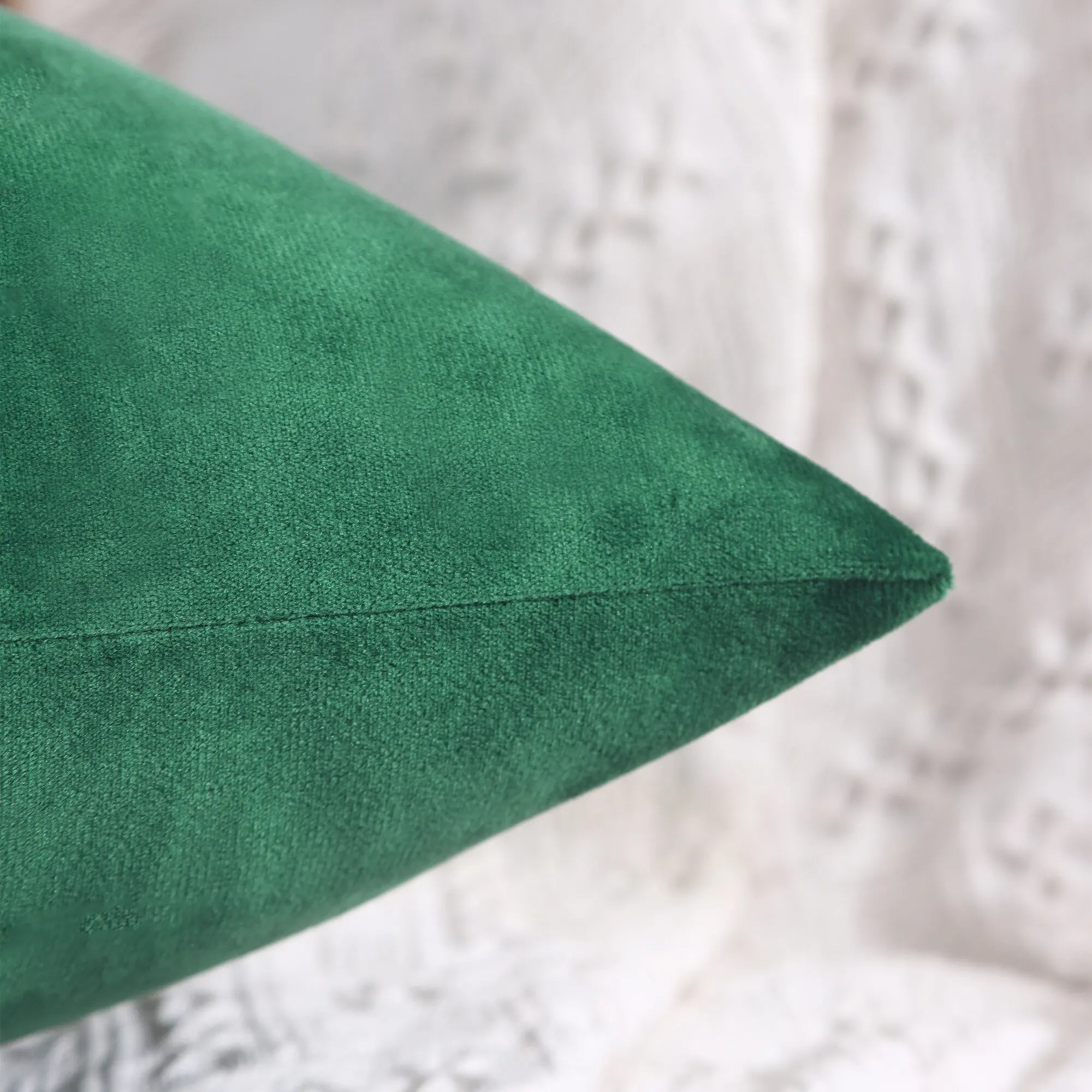 A Green cushion on a textured white background