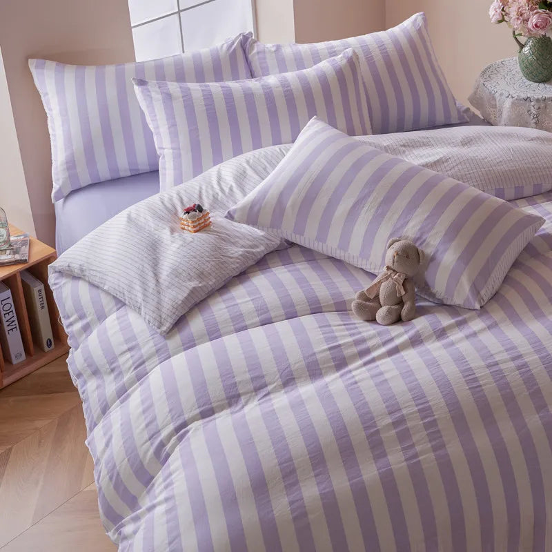 Lavender and white striped Polyester bedding set styled in a bright bedroom