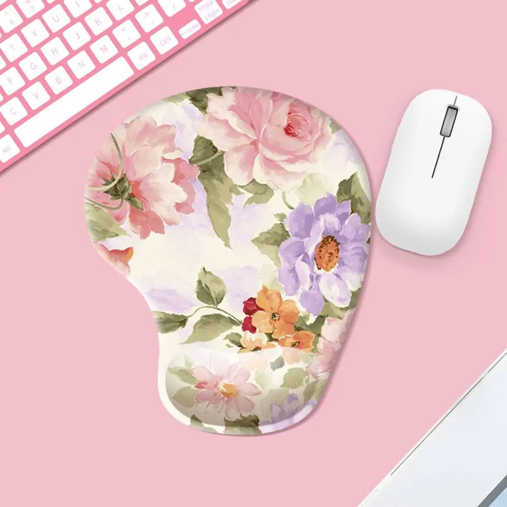 Floral mouse pad on a pink surface with a computer mouse and keyboard.
