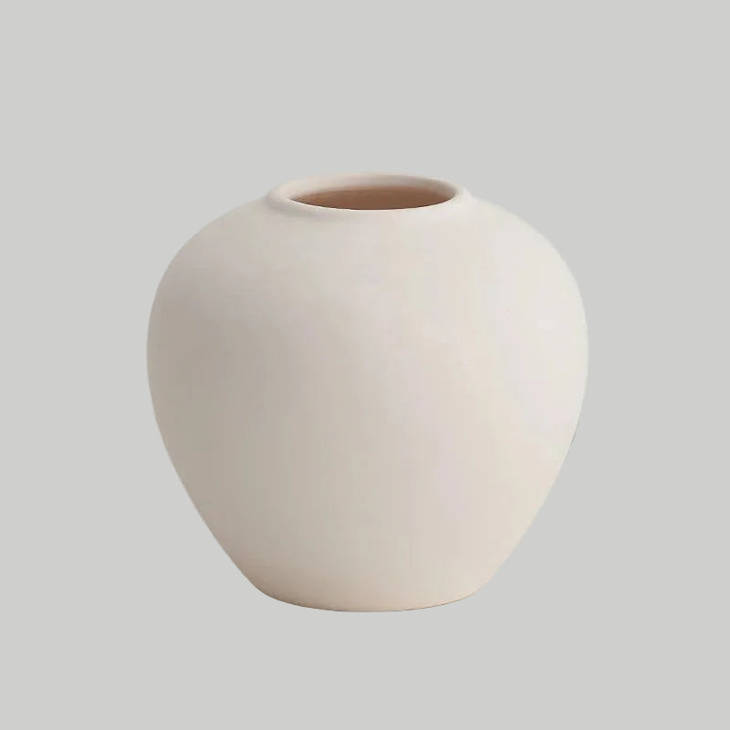 White ceramic vase on a light grey background.