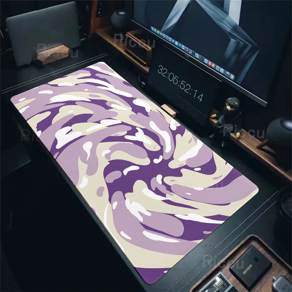 Purple and white camouflage mouse pad on a desk with computer equipment.