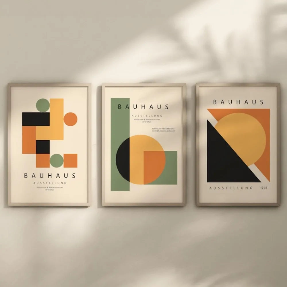 Three Bauhaus-style posters on a wall with geometric designs and 'Bauhaus' text.