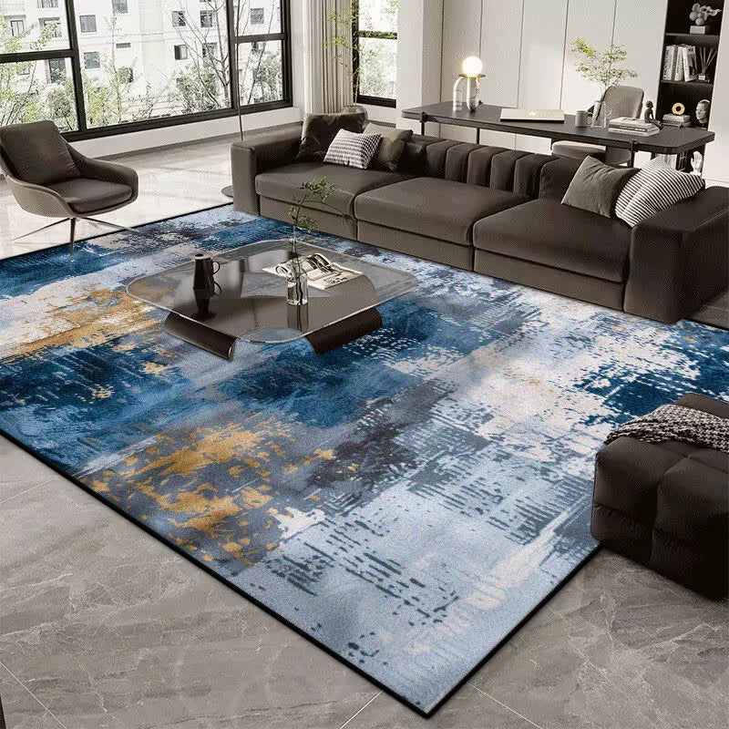 Living room with a large abstract blue and gold rug, dark sofa, and coffee table.