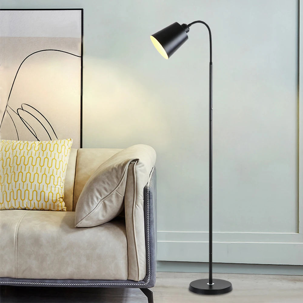 Modern floor lamp next to a beige sofa with yellow cushions in a living room setting.