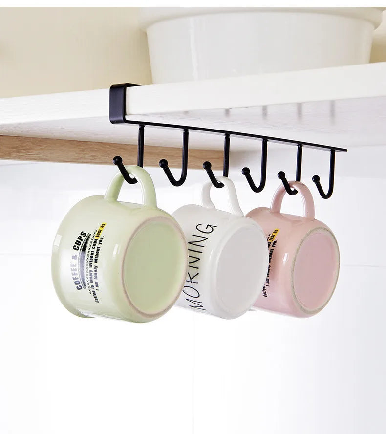Mug holder with three mugs hanging from it under a cabinet.