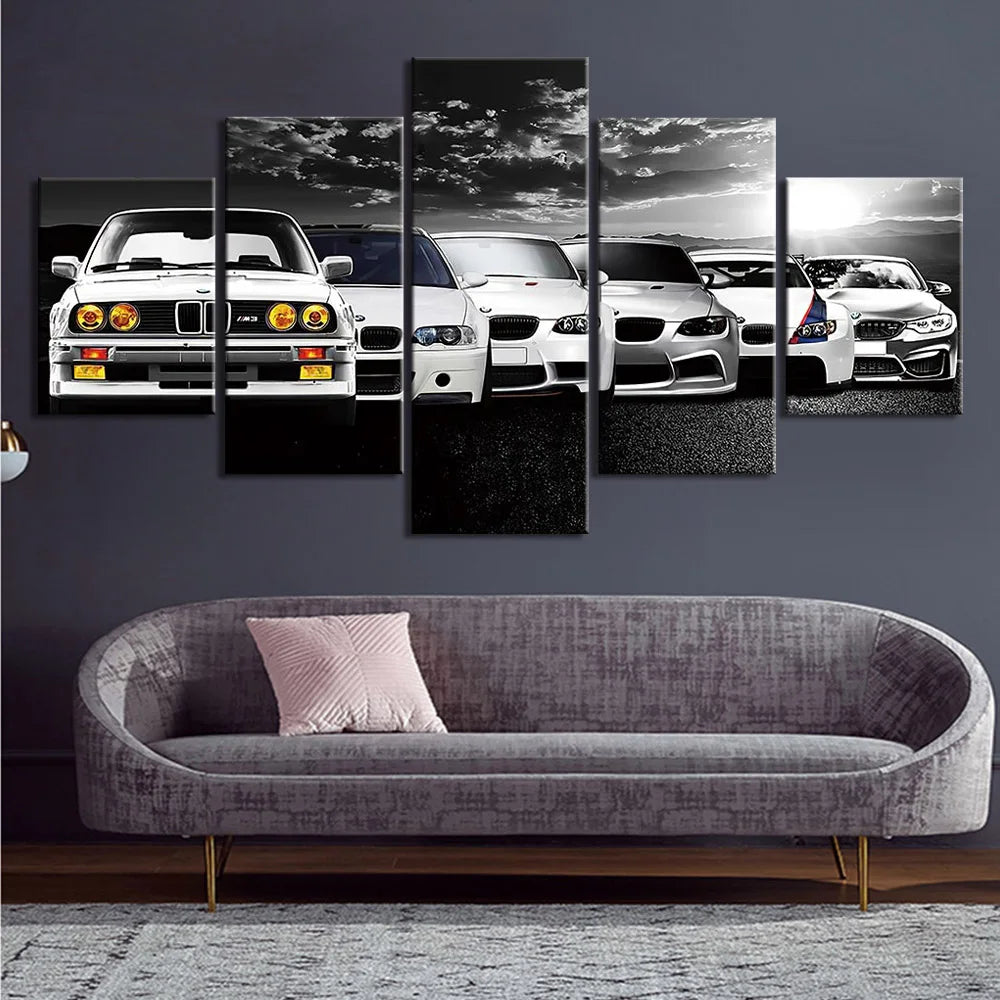 Wall art of BMW cars displayed on a dark wall above a grey sofa.