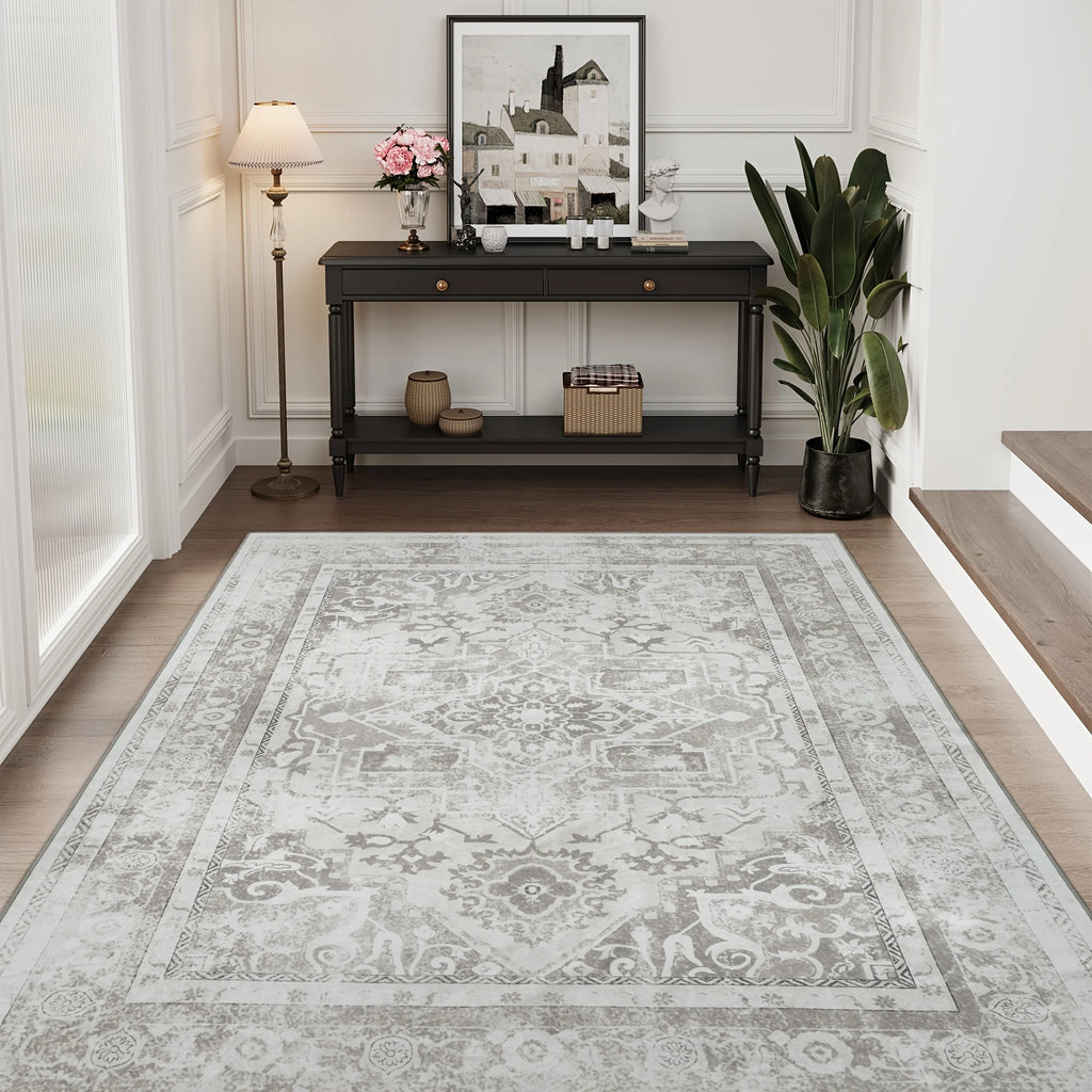 Silver grey vintage medallion rug with ornate border in a classic hallway with dark console table and floor lamp