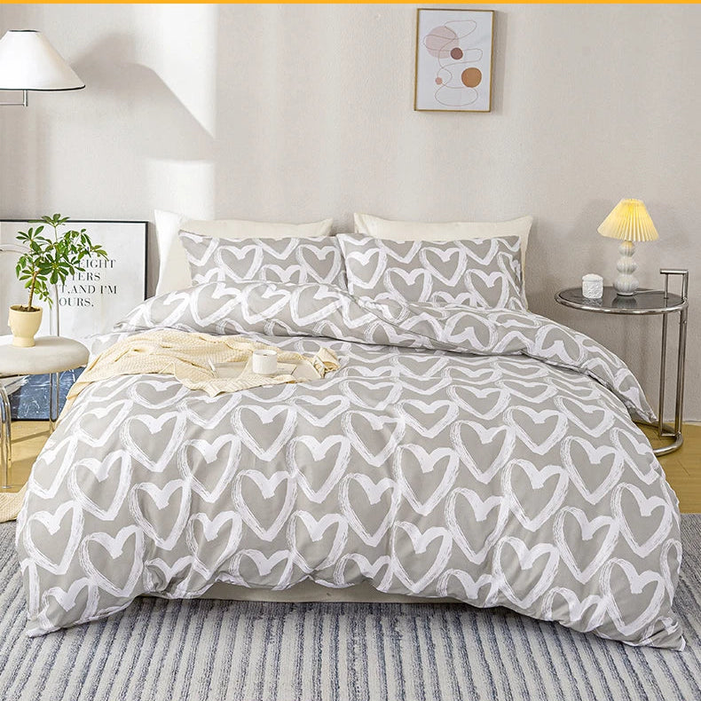 Gray and white heart-patterned comforter set on a bed in a bedroom.