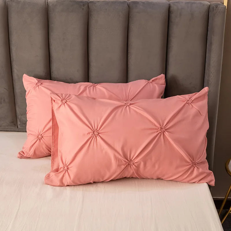 Pink textured pillows on a bed with a gray headboard