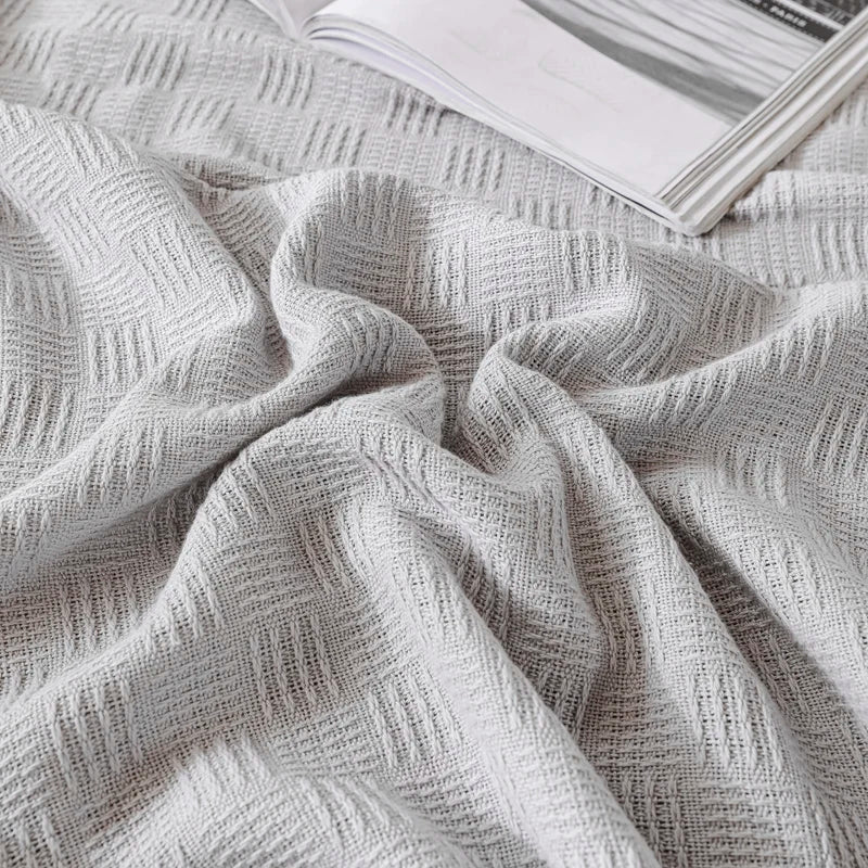 A silver grey knit throw blanket with open weave pattern.