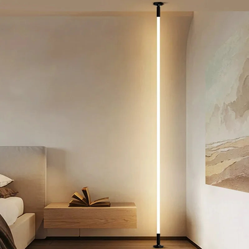 LED light positioned vertically beside a bed from floor to ceiling.