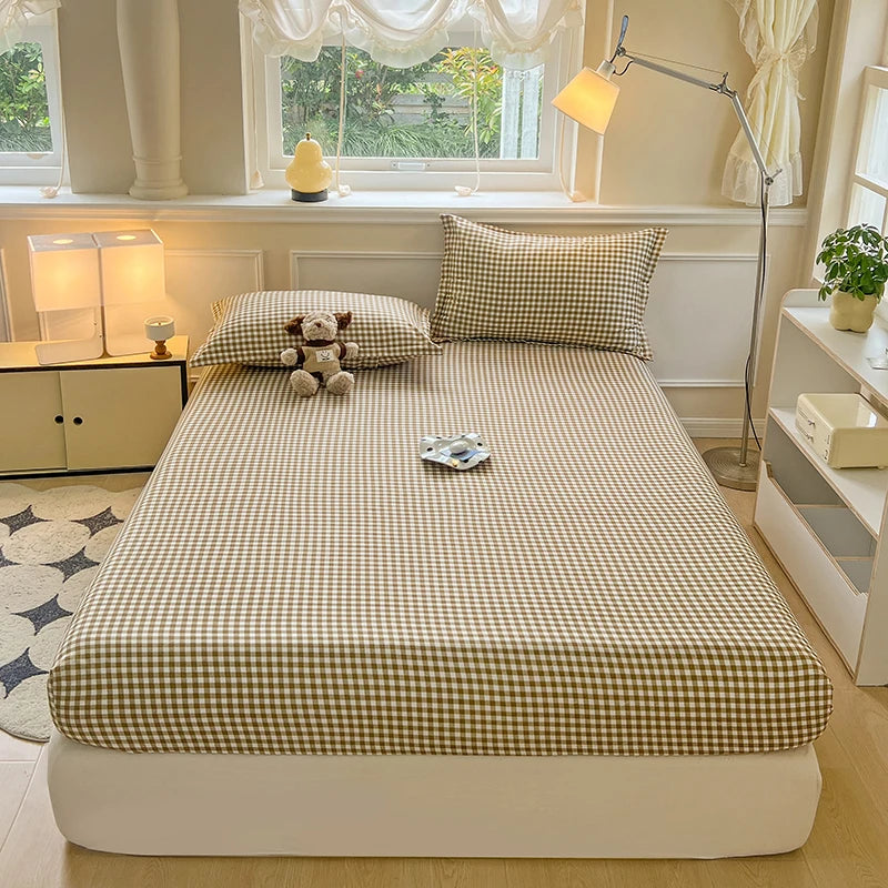 A classic tan and white checkered fitted sheet being tucked into a mattress. The image highlights the deep-pocket elastic fit and smooth Polyester fabric.