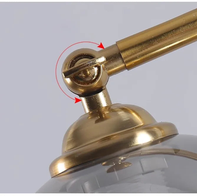 Brass hinge detail connecting curved arm to glass globe shade