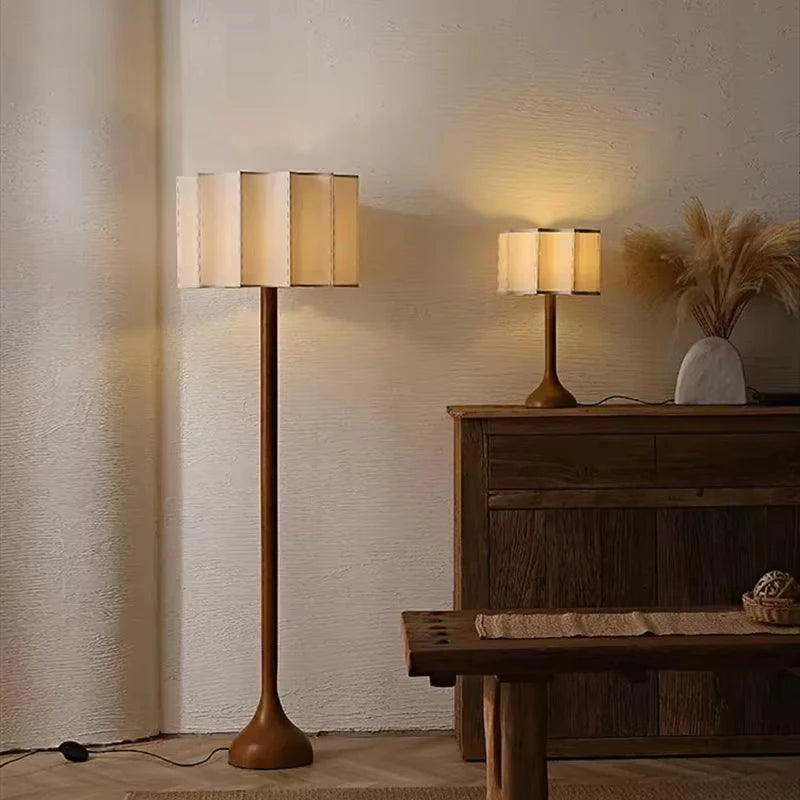 Two lamps, a floor lamp and a table lamp, in a room setting with wooden furniture.